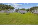 Wide backyard showcasing a picnic table and storage container sitting on the green grass at 4802 18Th St, Zephyrhills, FL 33542