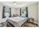 A neutral bedroom features natural light, luxury vinyl plank floors and is staged with a queen bed at 4802 18Th St, Zephyrhills, FL 33542