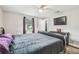 Bedroom featuring a ceiling fan, TV, black dresser, and black bed with dark bedding at 4802 18Th St, Zephyrhills, FL 33542