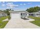 Charming home featuring a one-car garage, quaint porch with seating, and a well-manicured lawn at 4802 18Th St, Zephyrhills, FL 33542