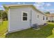 Exterior shot of the home with a vinyl siding, an AC unit, windows, and a green lawn at 4802 18Th St, Zephyrhills, FL 33542
