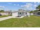 Charming home featuring a one-car garage, quaint porch with seating, and a well-manicured lawn at 4802 18Th St, Zephyrhills, FL 33542