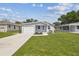 Charming home featuring a one-car garage, quaint porch with seating, and a well-manicured lawn at 4802 18Th St, Zephyrhills, FL 33542