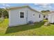 Exterior shot of the home with a vinyl siding, an AC unit, windows, and a green lawn at 4802 18Th St, Zephyrhills, FL 33542