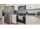 Well-lit kitchen featuring stainless steel appliances, white cabinets and gorgeous granite countertops at 4802 18Th St, Zephyrhills, FL 33542