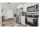 Modern kitchen featuring stainless steel appliances, white cabinets, and hardwood floors at 4802 18Th St, Zephyrhills, FL 33542