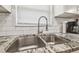 Close-up of kitchen sink showcasing granite countertops, subway tile backsplash, and modern fixtures at 4802 18Th St, Zephyrhills, FL 33542