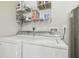 Functional laundry room with washer, dryer and wire shelving at 4802 18Th St, Zephyrhills, FL 33542