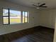 Bright living room featuring dark wood-look floors, a ceiling fan, and a large window showcasing the exterior at 502 Johnson Rd, Plant City, FL 33566