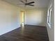 Spacious living room with dark wood-look floors, a ceiling fan, and a view into the hallway and back of the home at 502 Johnson Rd, Plant City, FL 33566