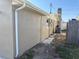 Side view of the home's exterior showing the gutter system, AC unit, and exterior textures at 5139 Victoria Ln, Holiday, FL 34690
