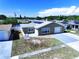 Attractive single-story home with solar panels, an attached garage, and a well-maintained lawn on a sunny day at 5139 Victoria Ln, Holiday, FL 34690