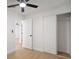 Bedroom with wood-look floors, white walls, ceiling fan, and closet at 5405 S Sellas St, Tampa, FL 33611