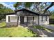 Charming single-story home featuring black and white exterior paint, brick accents, and well-manicured lawn at 5405 S Sellas St, Tampa, FL 33611