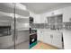 Close-up of a stylish kitchen with stainless steel appliances, white cabinetry, and a patterned backsplash at 5405 S Sellas St, Tampa, FL 33611