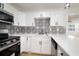 Bright kitchen featuring white cabinets, stainless steel appliances, a patterned backsplash, and modern lighting at 5405 S Sellas St, Tampa, FL 33611