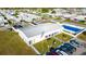 Aerial view of community center with a pool, lush landscaping, and car parking spaces at 5409 Antigua Dr, Zephyrhills, FL 33541