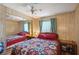 Bedroom with wooden paneling, a ceiling fan, and a full length mirrored closet at 5409 Antigua Dr, Zephyrhills, FL 33541