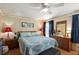 Charming bedroom featuring an attractive quilt, matching lamps, and a ceiling fan at 5409 Antigua Dr, Zephyrhills, FL 33541