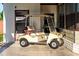 Tan golf cart parked next to a building, providing easy transportation around the community at 5409 Antigua Dr, Zephyrhills, FL 33541