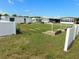 Horseshoe pits are surrounded by a green lawn and a white fence, providing a recreational amenity within the community at 5409 Antigua Dr, Zephyrhills, FL 33541