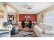 Cozy living room features a red accent wall, neutral furniture, and hardwood floors at 5409 Antigua Dr, Zephyrhills, FL 33541