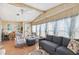 Cozy living room with vaulted ceilings, wood-look walls, comfortable seating, and abundant natural light at 5409 Antigua Dr, Zephyrhills, FL 33541
