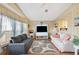 Bright and inviting living room features wood-look walls, cozy sofas, and large windows offering plenty of natural light at 5409 Antigua Dr, Zephyrhills, FL 33541