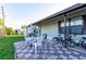 Outdoor patio with a checkered tile floor, dining table, umbrella, chairs, and bicycles at 5409 Antigua Dr, Zephyrhills, FL 33541