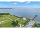 Scenic aerial view showcasing a waterfront park with a covered structure, green space, and pier access at 56 Bay Woods Dr, Safety Harbor, FL 34695