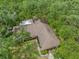 Aerial view of a home with a brown roof surrounded by mature trees on a sunny day at 56 Bay Woods Dr, Safety Harbor, FL 34695