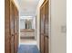 Hallway view into a bathroom with dual sinks and closet doors along the hall and blue carpet at 56 Bay Woods Dr, Safety Harbor, FL 34695