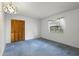 Bright bedroom features blue carpeting, white walls, window with blinds and wood closet doors at 56 Bay Woods Dr, Safety Harbor, FL 34695