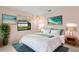 Bright bedroom featuring a queen bed with an art piece above, two lamps and a plant at 56 Bay Woods Dr, Safety Harbor, FL 34695