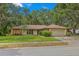 Well-maintained single-story home features a two-car garage, manicured lawn and mature trees at 56 Bay Woods Dr, Safety Harbor, FL 34695