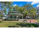 Community gazebo with benches surrounded by green grass and large trees in a park setting at 56 Bay Woods Dr, Safety Harbor, FL 34695