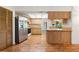 Functional kitchen with wooden cabinets, stainless steel refrigerator, and wood-look flooring at 56 Bay Woods Dr, Safety Harbor, FL 34695