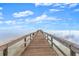 A straight wooden pier extending over calm waters to the horizon under a bright sky at 56 Bay Woods Dr, Safety Harbor, FL 34695