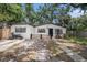 Charming single-story home with white exterior, black trim, mature trees, and motorcycle parked near driveway at 5801 92Nd N Ave, Pinellas Park, FL 33782