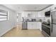 Open kitchen boasts stainless steel appliances, white cabinetry, and tile backsplash at 5801 92Nd N Ave, Pinellas Park, FL 33782