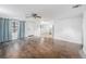 Open-concept living room with hardwood floors, ceiling fan and ample natural light from windows at 5801 92Nd N Ave, Pinellas Park, FL 33782
