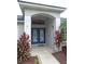 Arched entryway featuring double doors with decorative glass panels and manicured landscaping at 5815 Heronview Crescent Dr, Lithia, FL 33547