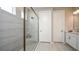 Modern bathroom featuring a glass-enclosed shower, white cabinets, and light tile flooring at 714 Sky Shade Dr, Apollo Beach, FL 33572