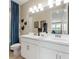 Bright bathroom featuring dual sinks, a large mirror, white cabinetry, and blue-themed decor, offering a clean and modern feel at 727 Steel Dr, Apollo Beach, FL 33572