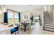 Bright dining area with large windows, modern furniture, and adjacent living space at 727 Steel Dr, Apollo Beach, FL 33572