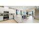 Open kitchen features a central island with sink, light cabinets and stairs to the second floor at 727 Steel Dr, Apollo Beach, FL 33572