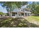 Back of the house with backyard, showing the elevated construction style and covered outdoor entertainment area at 7300 Mackerel Ln, Hudson, FL 34667