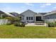 Large backyard featuring a patio, lawn, and a white home exterior at 7309 S Shamrock Rd, Tampa, FL 33616