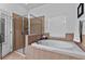 Bright bathroom featuring a soaking tub, separate shower, and tile surround at 7309 S Shamrock Rd, Tampa, FL 33616