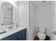 Stylish half-bathroom with white walls, dark blue vanity and chrome fixtures at 7309 S Shamrock Rd, Tampa, FL 33616